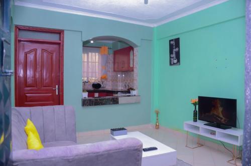 a living room with a purple couch and a red door at Amani Homes in Eldoret