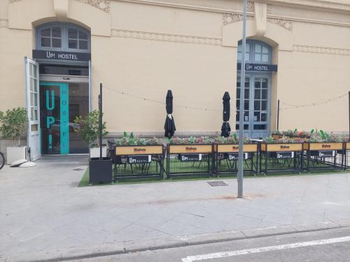 a group of tables with umbrellas in front of a building at UP Hostel Valencia in Valencia
