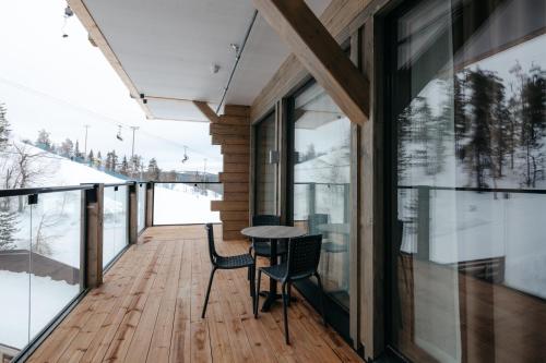 a room with a table and chairs on a wooden deck at Ski-Inn Kultakero in Pyhätunturi