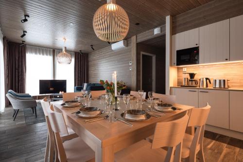 a dining room with a large wooden table with chairs at Ski-Inn Kultakero in Pyhätunturi