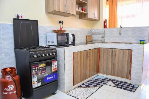 a kitchen with a stove and a microwave at Dala Suites in Kakamega