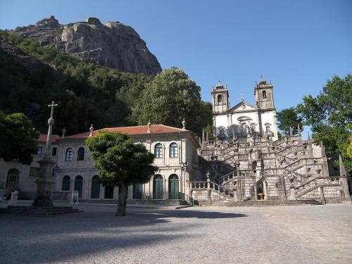 un antiguo edificio con una iglesia frente a una montaña en Casa da Laurinha, en Arcos de Valdevez