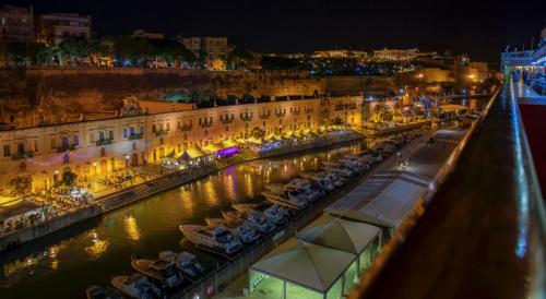 Old Mint Penthouse في فاليتا: ميناء تتواجد فيه قوارب في الماء ليلاً
