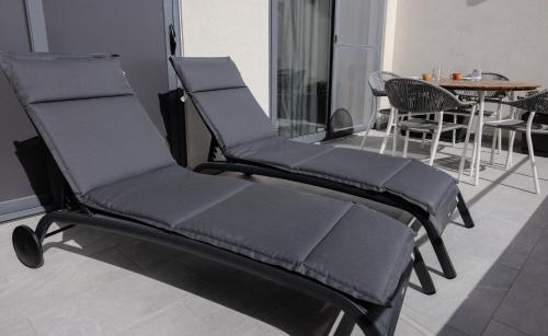 Duas cadeiras numa sala de estar com uma mesa em Penthouse With Sunny Terrace em Msida