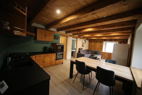 een keuken met een grote houten tafel en stoelen bij Chez Lydie in Fellering