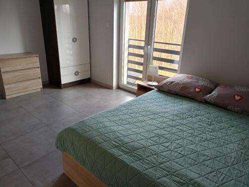a bedroom with a bed and a large window at Willa w Brzozach Sznurki Spokojna 1 - Chmielno, Kaszuby, dom, jezioro in Chmielno