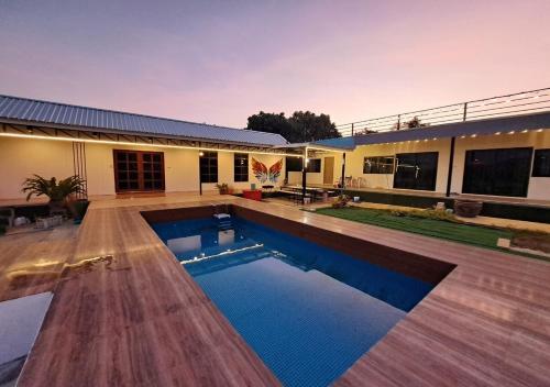 a house with a swimming pool in the yard at Lsarl Pool Villa อิฏฐ์สรี พูลวิลล่า in Wangkata