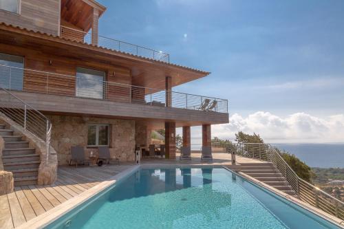uma casa com piscina em frente a uma casa em Les Terrasses de Scalegiu em Porto-Vecchio