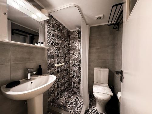 a small bathroom with a sink and a toilet at Ten Number Suites in Limenas