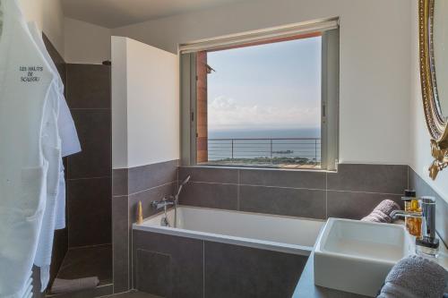 La salle de bains est pourvue d'une baignoire et d'une fenêtre. dans l'établissement Les Terrasses de Scalegiu, à Porto-Vecchio