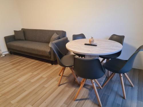 - un salon avec une table, des chaises et un canapé dans l'établissement THEOX No 3 in Duisburg, à Duisbourg