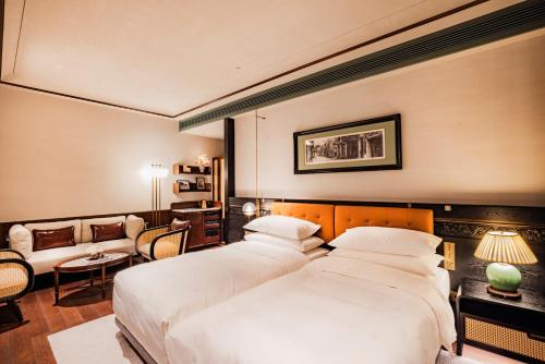 a hotel room with two beds and a couch at Hotel Central 新中央酒店 in Macau