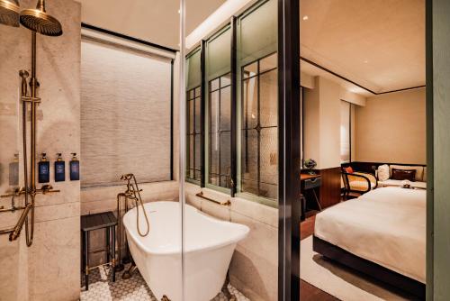 uma casa de banho com uma banheira e um quarto com uma cama em Hotel Central Macau em Macau