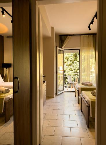 a hotel room with two beds and a balcony at Ten Number Suites in Limenas