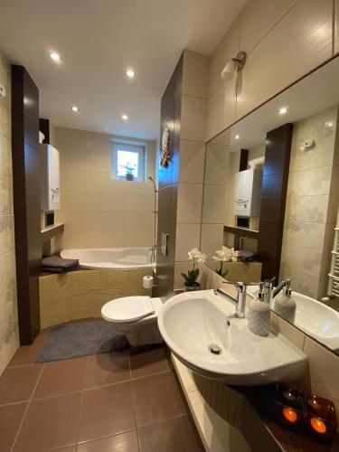 łazienka z 2 umywalkami, toaletą i wanną w obiekcie Colibri Apartament Lubniewice w Lubniewicach