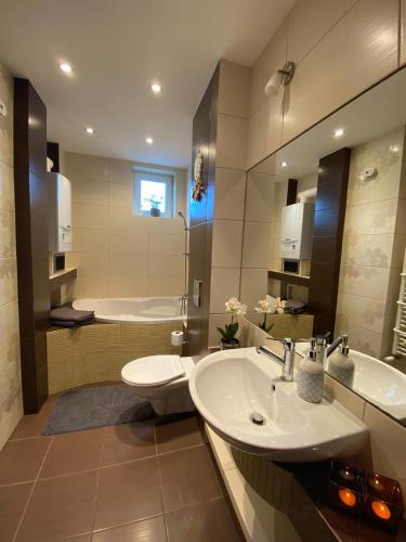 a bathroom with two sinks and a toilet and a tub at Colibri Apartament Lubniewice in Lubniewice