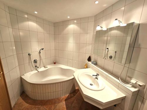 een badkamer met een groot bad en een wastafel bij Ferienwohnung Eiden in Oberstdorf