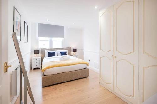 a white bedroom with a bed and a closet at London Fitzrovia CityApartmentStay in London