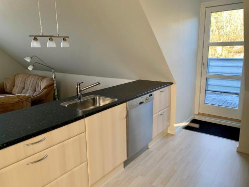 een keuken met een wastafel en een aanrecht bij 2 voksne + 2 børn in Læsø