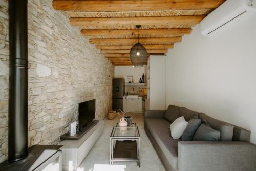 a living room with a couch and a stone wall at Smaragda's Guest Rooms in Limassol