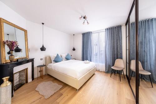 - une chambre avec un lit, une cheminée et un miroir dans l'établissement Appartement Prestige Champs Elysées, à Suresnes