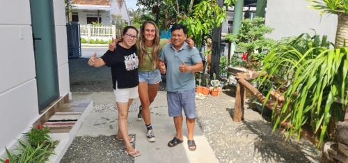 three people posing for a picture in front of a house at Sunrise Dốc Lết in Ninh Hai