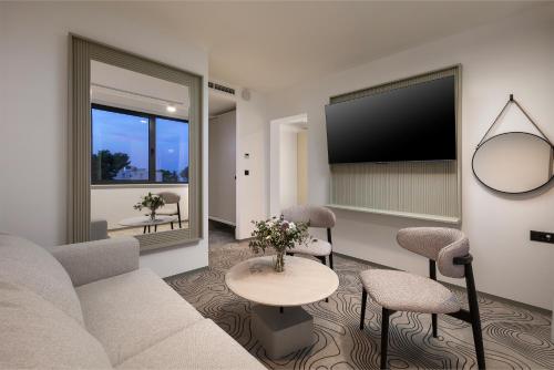 a living room with a couch and a tv at SeeSea Hotel in Vodice