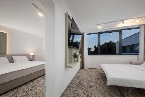 a bedroom with two beds and a window at SeeSea Hotel in Vodice