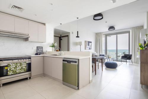 a kitchen with white appliances and a dining room at Frank Porter - 1 Residences in Dubai