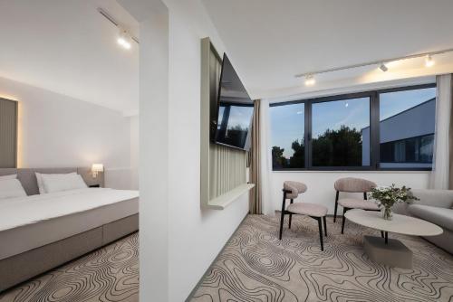a hotel room with a bed and a table and chairs at SeeSea Hotel in Vodice