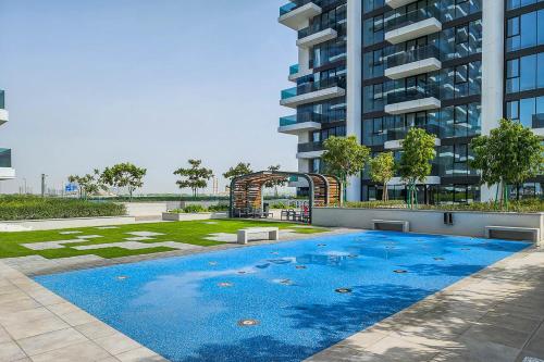 a swimming pool in front of a tall building at Frank Porter - 1 Residences in Dubai