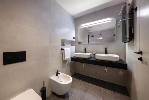 a bathroom with two sinks and a toilet at SeeSea Hotel in Vodice