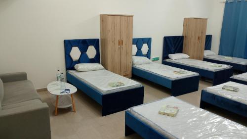 a room with four beds and a couch at Corniche ajman 2 in Ajman 