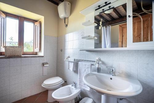 Baño blanco con lavabo y aseo en Bosco ad Antico Casale '700, en Umbertide