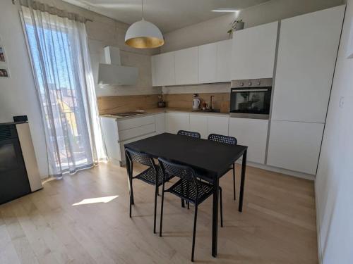 cocina con mesa y sillas en una habitación en Appartamento Ilaria, en Dueville