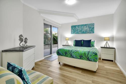 a bedroom with a bed and a window at Iluka Resort Apartments Palm Beach in Palm Beach