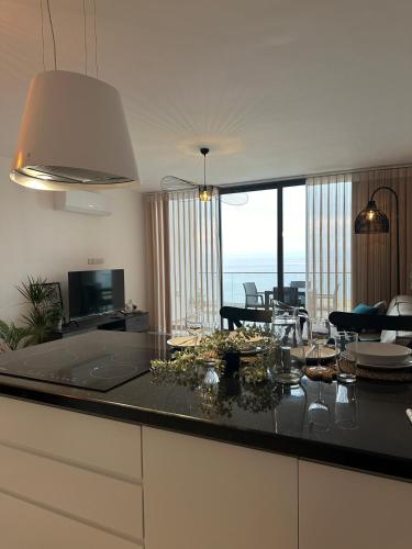 a kitchen and living room with a view of the ocean at Penthouse i sjøkanten på Dejablue in Kérynia