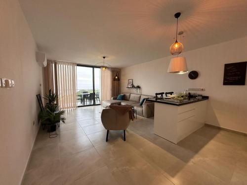 a kitchen and living room with a couch and a table at Penthouse i sjøkanten på Dejablue in Kyrenia