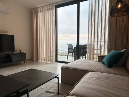a living room with a couch and a view of the ocean at Penthouse i sjøkanten på Dejablue in Kérynia