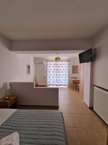 1 dormitorio con 1 cama, cocina y mesa en Porto Xronia, en Khrónia