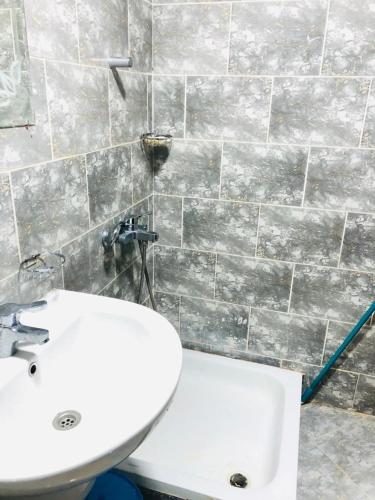 a bathroom with a white sink and a toilet at شاليه in El Alamein