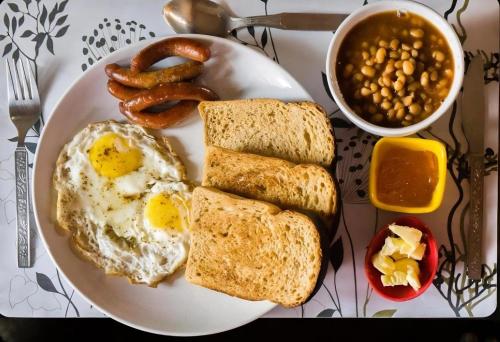 ein Frühstücksteller mit Eiern, Brot und Bohnen in der Unterkunft Hotel Baga Bliss By Celestiial Hospitality, Baga North Goa in Goa