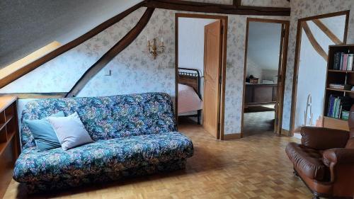 ein Wohnzimmer mit Sofa und ein Schlafzimmer in der Unterkunft Chambres d’Hôtes Les Melogottes in Villapourçon