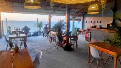 a restaurant with tables and chairs and a view of the ocean at Scandinavian Beach Resort in Ko Lanta