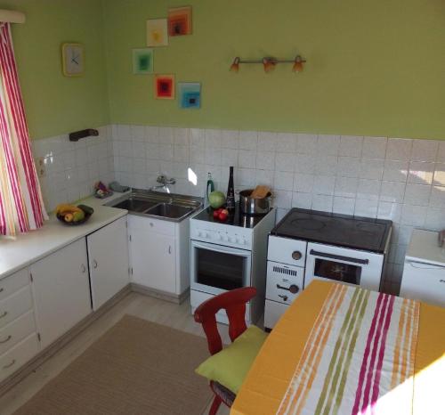 a kitchen with a sink and a stove and a table at Ferienwohnung in ruhiger Lage am Waldrand - b55795 in Navis