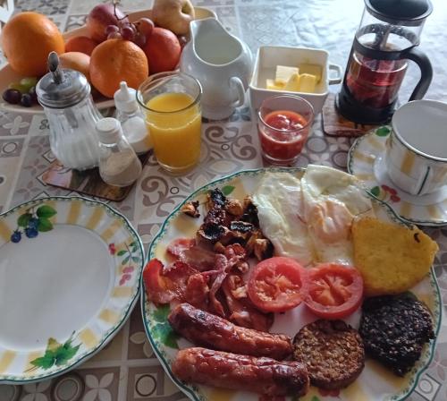 un plato de desayuno con huevos, salchichas y tomates en Cuan na bPiobairí en Mullingar