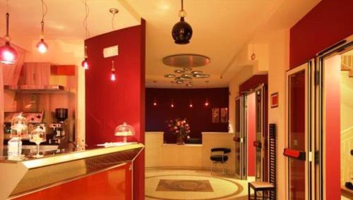 a large kitchen with red walls and a kitchen with a counter at Palace Hotel Una Nuova Strada in Nocera Terinese