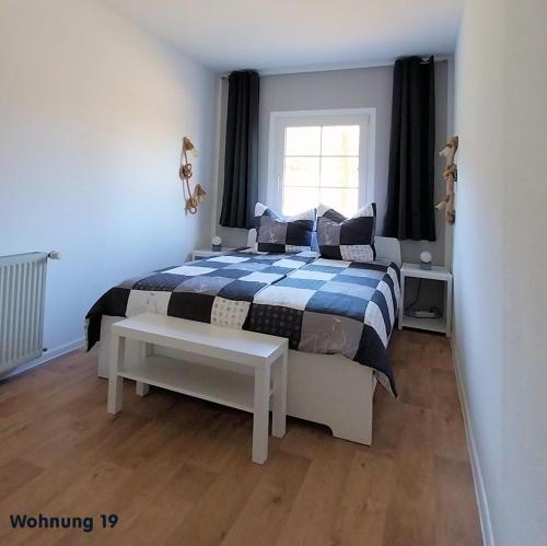 a bedroom with a bed with a blue and white blanket at Zeit für Erholung, Ferienhaus A&C Prudlo, Usedom in Lütow