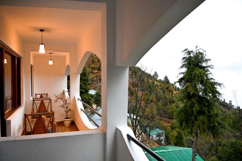 an indoor balcony with a view of a mountain at Kumaon Roop Resort Near Neem Karoli Temple in Nainital