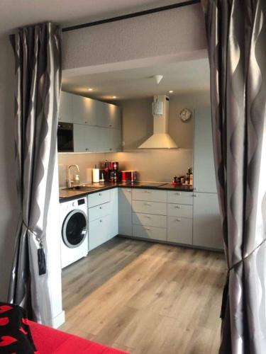 une cuisine avec des armoires blanches et une laveuse et une sécheuse dans l'établissement Naturiste Cap d'Agde Héliopolis F 31, au Cap d'Agde